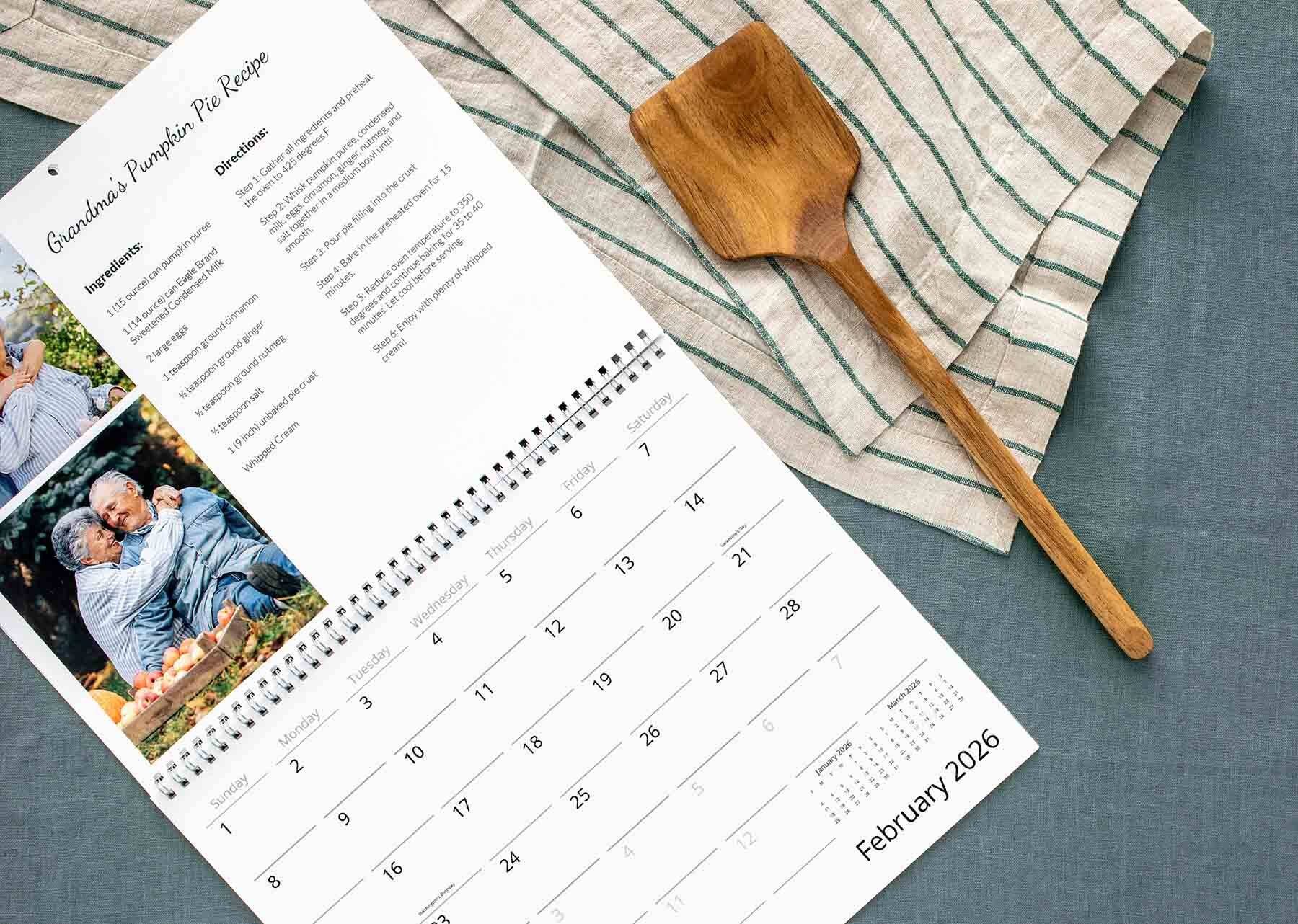 Custom wall calendar with white spiral binding, recipe and personal photos at the top, open to February 2026