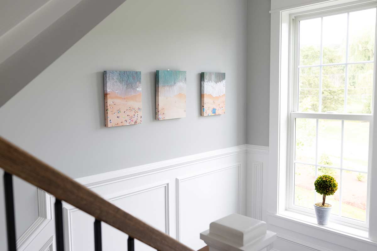 Three canvases of beach photos on a wall