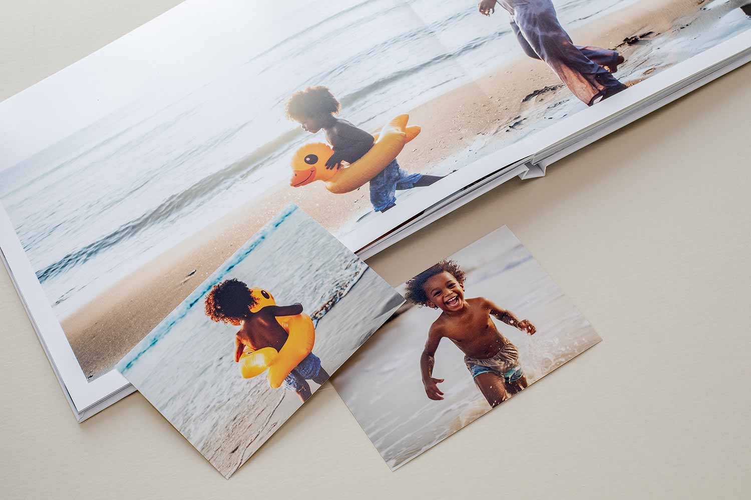 Layflat photo book and printed photos from a summer beach trip