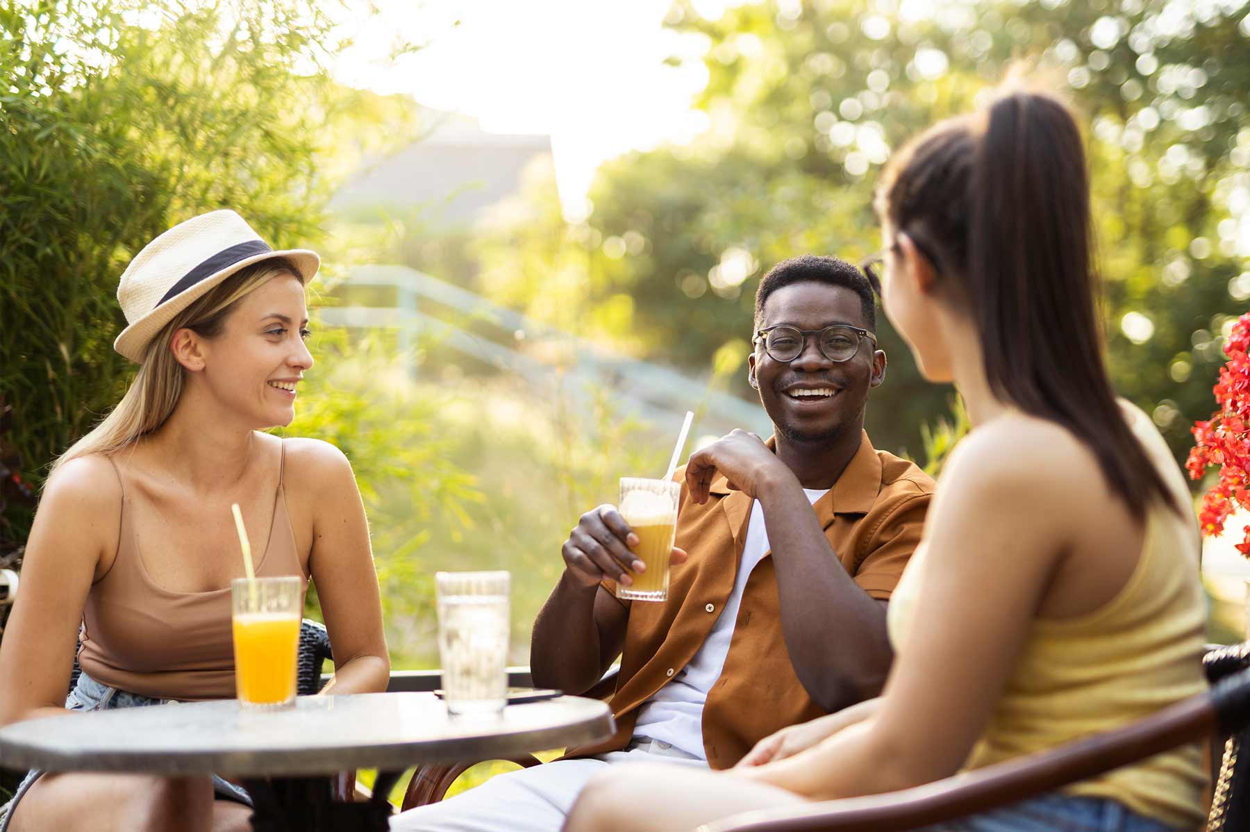 Candid summer moment of three friends eating breakfast together