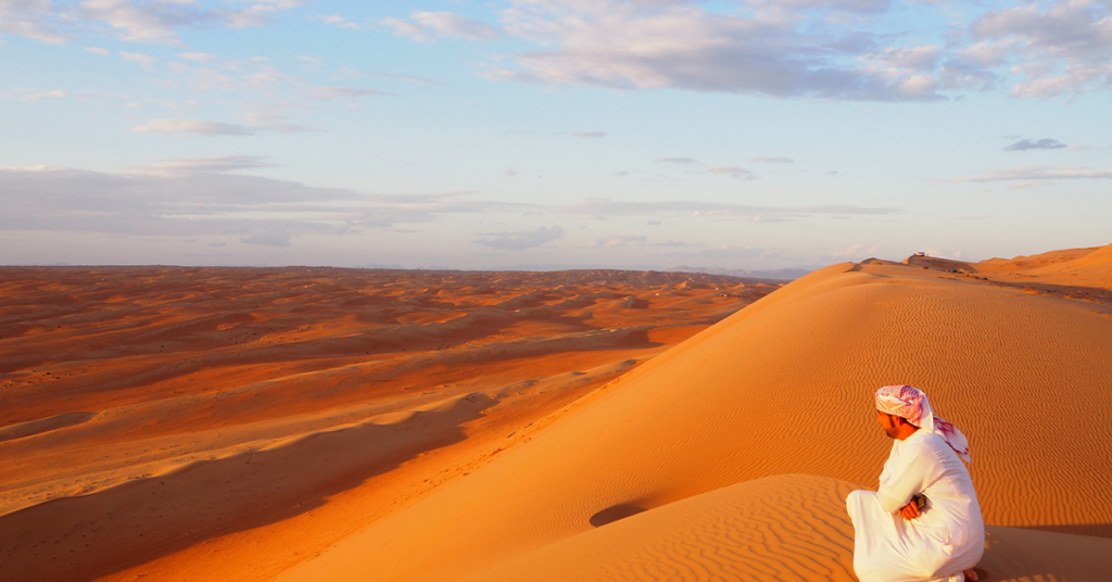 The person in the foreground leads the viewer right into the desert behind him.