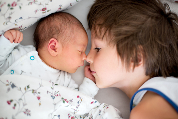 Capture those first special moments between siblings.